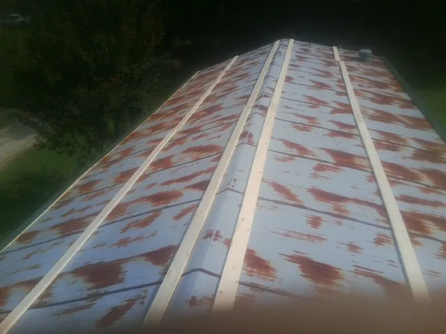 Rusted metal roof panels with new wood purlins before replacement — Storm Damage Roof Repair in Tome by Roofing Brothers
