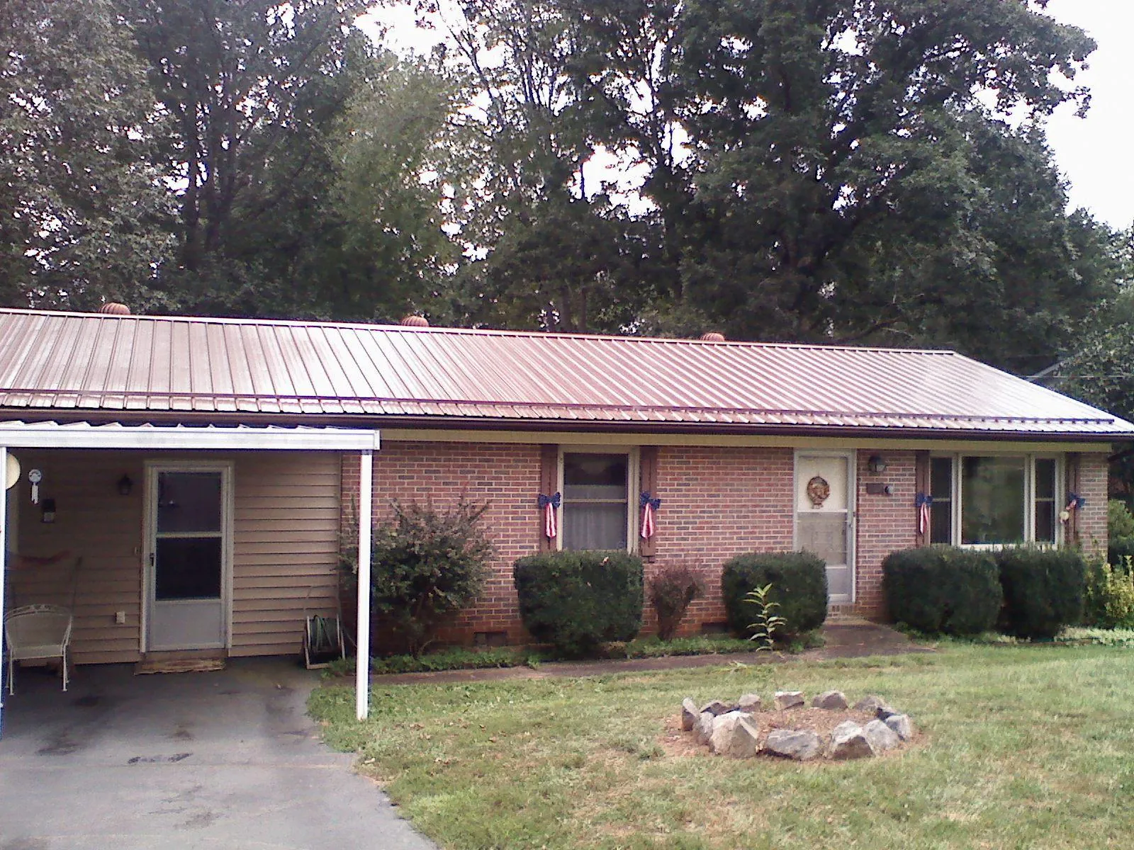 Bronze metal roof and carport on a brick ranch home — Roof Repair work by our crew in Tome