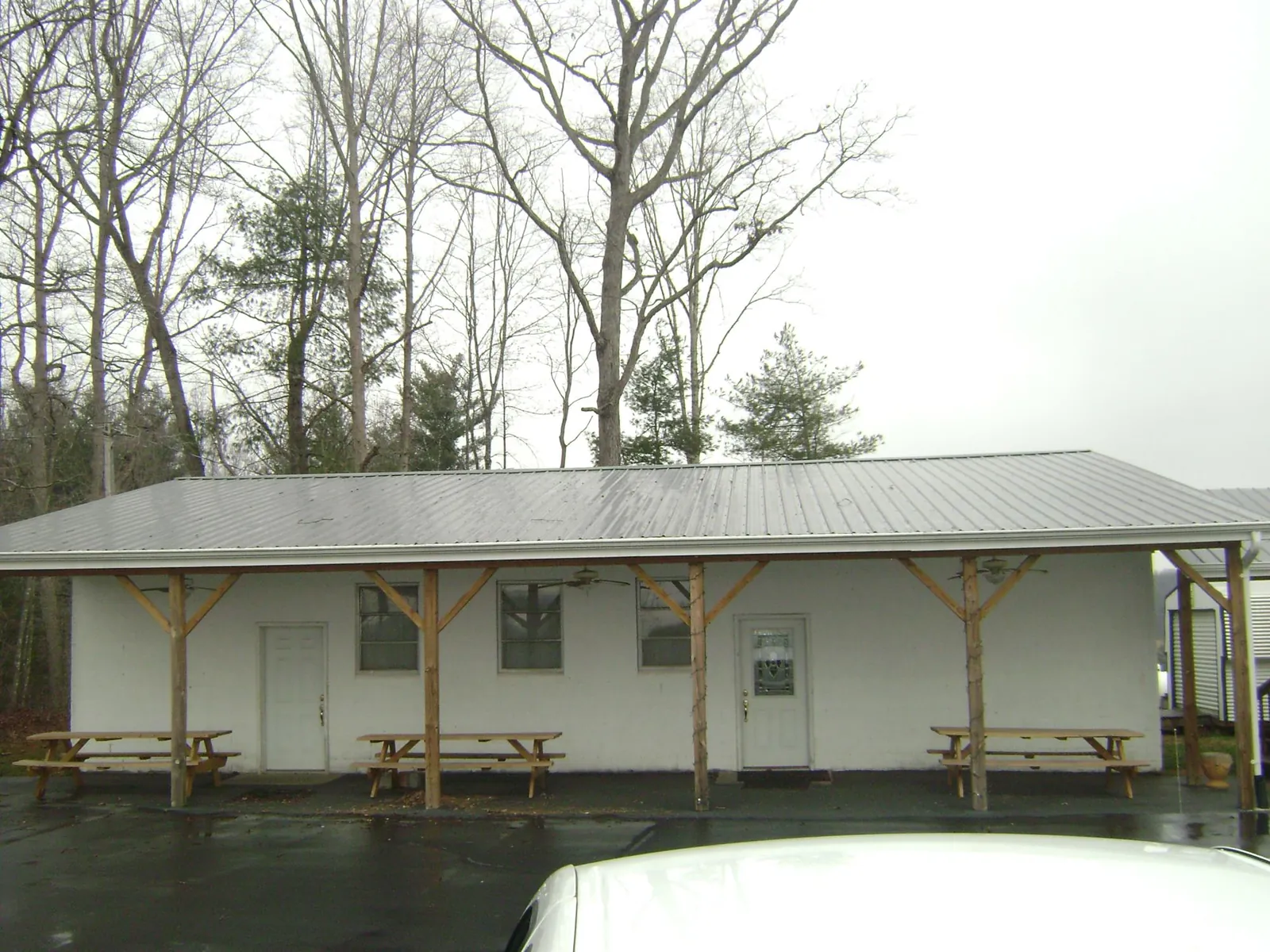 Gray metal roof over a block building with a timber post porch in Tome